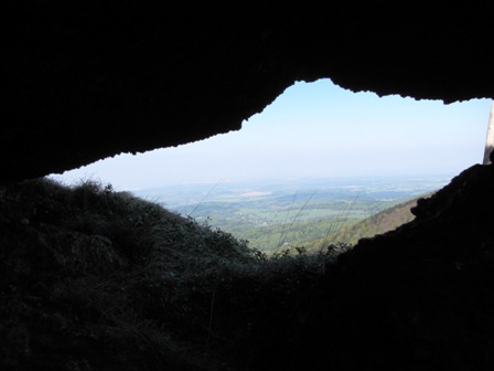 Blick durch einen Felsspalten ins weite Land