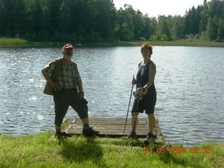 Monika posiert mit einem neuen Wanderfreund am Ufer eines Teiches